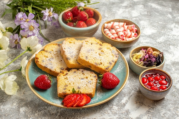 Vorderansicht leckere Kuchenstücke mit Erdbeeren auf süßer Torte der leichten Oberfläche Obstkuchen