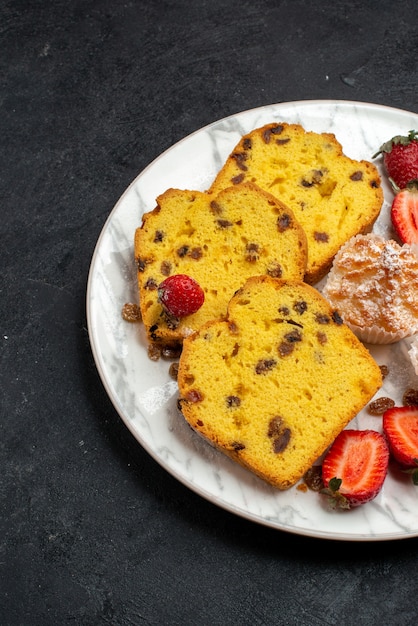 Vorderansicht leckere Kuchenstücke mit frischen roten Erdbeeren und Keksen auf grauer Oberfläche Kuchen backen Kekskuchen Zucker süßen Keks