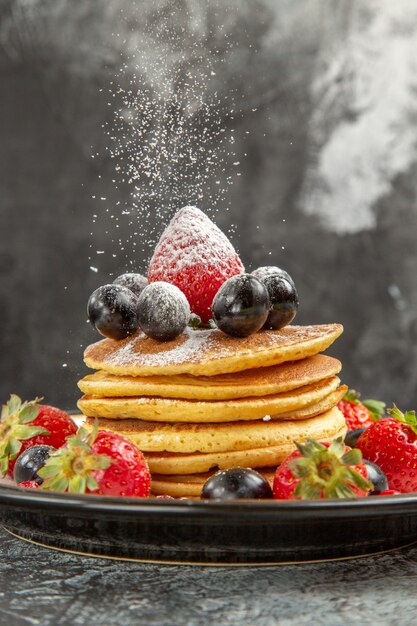 Vorderansicht leckere Pfannkuchen mit frischen Früchten auf der leichten Oberfläche Frühstück süße Früchte