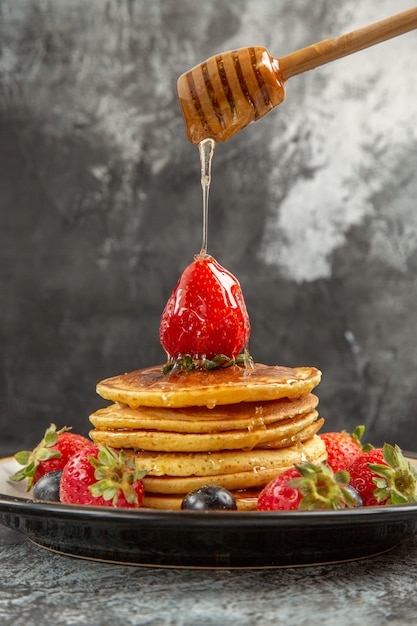 Vorderansicht leckere Pfannkuchen mit frischen Früchten auf der leichten Oberfläche Frühstück süße Früchte