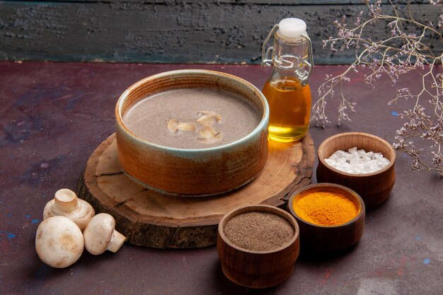 Vorderansicht leckere Pilzsuppe mit verschiedenen Gewürzen auf dem dunklen Raum