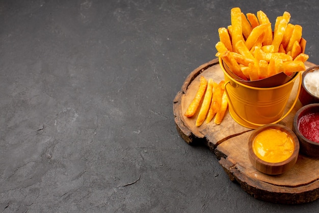 Vorderansicht leckere Pommes frites mit Saucen auf dunklem Raum