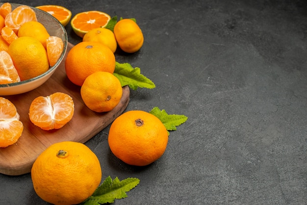 Kostenloses Foto vorderansicht leckere saftige mandarinen im teller auf dunklem hintergrund sauer exotische zitrusfrüchte