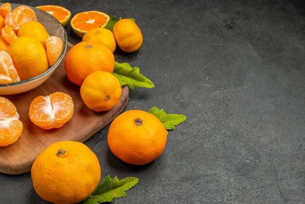 Vorderansicht leckere saftige Mandarinen im Teller auf dunklem Hintergrund sauer exotische Zitrusfrüchte