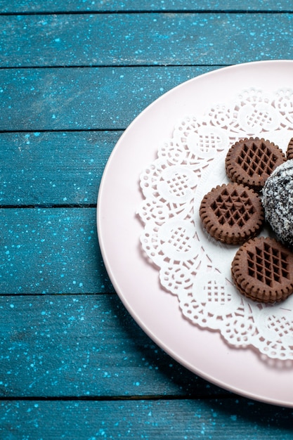 Vorderansicht leckere Schokoladenkekse mit Schokoladenkuchen auf dem blauen rustikalen Schreibtischkuchen Kakaotee süßer Keksplätzchen