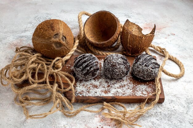 Vorderansicht leckere Schokoladenkuchen mit Kokosnuss auf der hellweißen Oberfläche backen Kekszuckerkuchen süße Keksschokolade