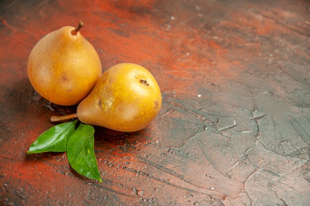 Vorderansicht leckere süße Birnen auf dunklem Hintergrund Fruchtfleisch Apfel Foto Obstbaum