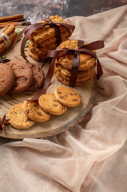 Vorderansicht leckere süße Kekse mit Tasse Kaffee auf der hellen Hintergrundfarbe Kakao-Zucker-Tee-Kuchen-Cookies süßer Kuchen