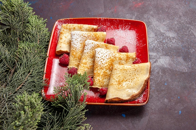 Vorderansicht leckere süße Pfannkuchen mit Himbeeren auf dunklem Raum