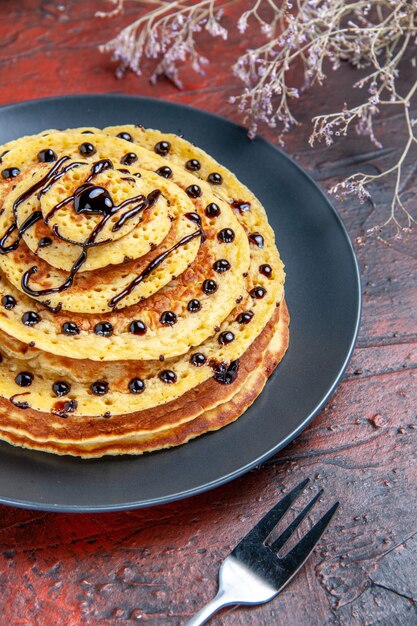 Vorderansicht leckere süße Pfannkuchen mit Zuckerguss auf dunklem Boden Milch süßer Dessertkuchen