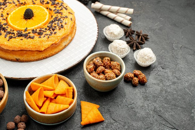 Vorderansicht leckere süße Torte mit Orangenscheiben auf dunkelgrauem Hintergrund Teig Obstkuchen Kuchen Keks