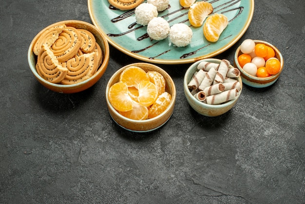 Vorderansicht leckere Zuckerkekse mit Bonbons auf grauem Schreibtischkeksplätzchenkuchen