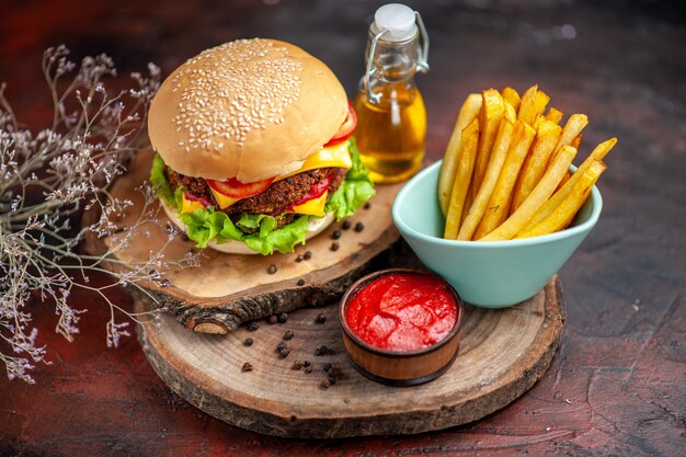 Vorderansicht leckeren Fleischburger mit Pommes Frites auf dunklem Hintergrund