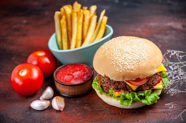 Vorderansicht leckeren fleischburger mit pommes frites auf dunklem hintergrund