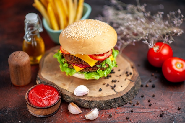 Vorderansicht leckeren Fleischburger mit Pommes Frites auf dunklem Schreibtisch