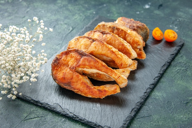 Vorderansicht leckeren gebratenen Fisch auf der dunklen Oberfläche Pfeffer Kochgericht Salat Braten Mahlzeit Meeresfrüchte Meeresfleisch Essen