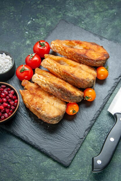 Vorderansicht leckeren gebratenen Fisch mit Tomaten auf dunkelblauer Oberfläche Lebensmittel Salat Mahlzeit Fleisch Meeresfrüchte Meeresfrüchte Bratgericht