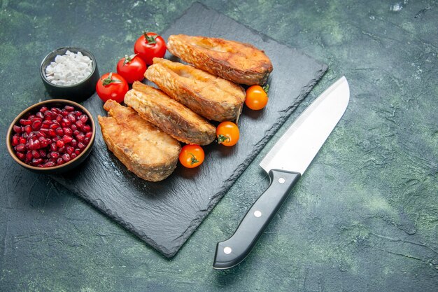 Vorderansicht leckeren gebratenen Fisch mit Tomaten auf dunkler Oberfläche Lebensmittel Salat Mahlzeit Fleisch Meeresfrüchte Meereskochbraten Gericht