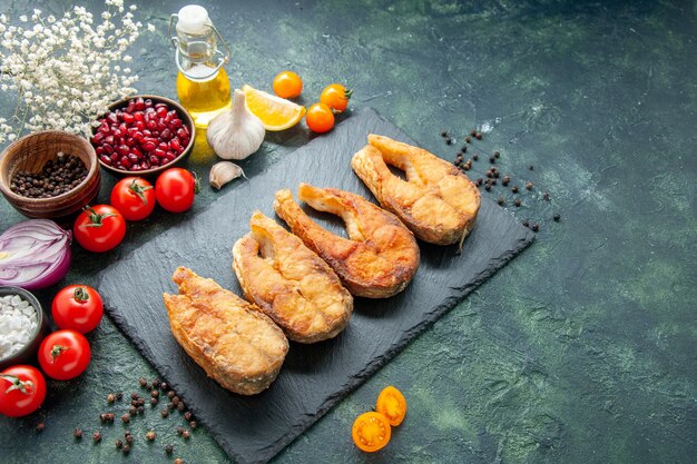 Vorderansicht leckeren gebratenen Fisch mit Tomaten auf einem dunklen Hintergrund Kochgericht Salat Braten Mahlzeit Meeresfrüchte Pfeffer Meeresfleisch Essen