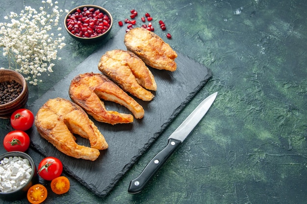 Vorderansicht leckeren gebratenen Fisch mit Tomaten auf einem dunklen Hintergrundgericht Essenssalat Braten Fleisch Seepfeffer kochen Mahlzeit Meeresfrüchte