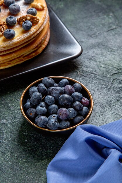 Vorderansicht leckeren Honigkuchen mit Blaubeeren und Walnüssen innerhalb Platte dunkle Oberfläche