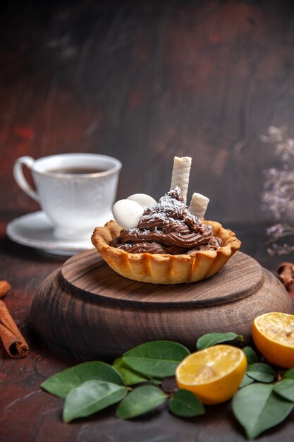 Vorderansicht leckerer cremiger Kuchen auf dunklem Tischdessert süßer Kekskuchen