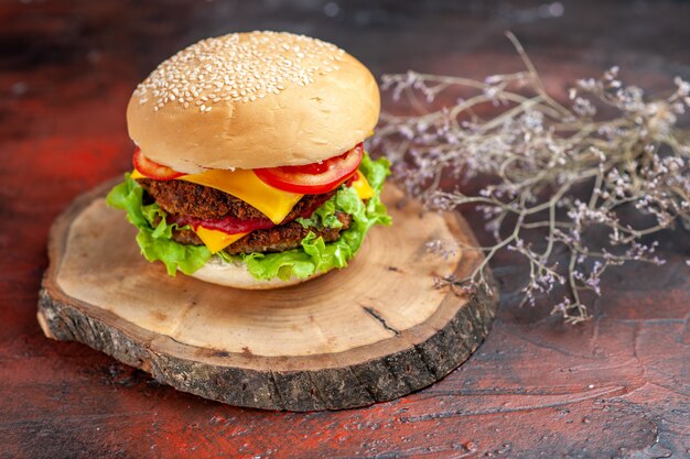 Vorderansicht leckerer Fleischburger mit Käse und Salat auf dem dunklen Hintergrund