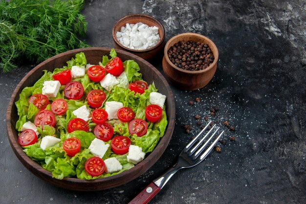 Vorderansicht leckerer Gemüsesalat mit geschnittenen Käsetomaten und Gewürzen auf dunklem Hintergrund Essen Mahlzeit Diät Mittagessen Farbe Gesundheit