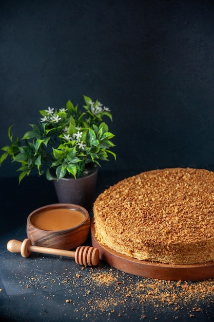 Kostenloses Foto vorderansicht leckerer honigkuchen auf der dunklen oberfläche