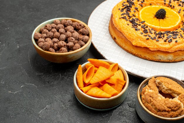 Vorderansicht leckerer süßer Kuchen mit Orangenscheiben auf dunkelgrauem Schreibtisch süßer Kuchen Dessert-Tee-Keks