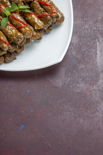 Kostenloses Foto vorderansicht leckeres blatt dolma hackfleischgericht im teller auf dunklem schreibtisch fleischgericht blattessen