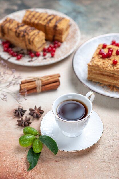 Vorderansicht leckeres Kuchenstück mit Tee und Beeren auf Licht