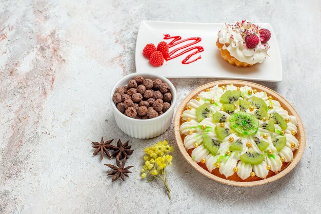 Vorderansicht leckeres Sahnedessert mit Kiwis auf weißem Schreibtischkuchen Sahnedessert