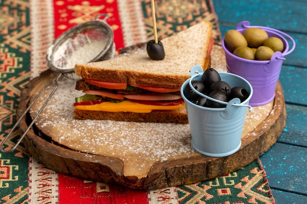 Vorderansicht leckeres Toastsandwich mit Käseschinken innen zusammen mit Mehloliven auf Blau