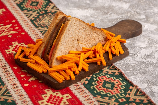 Vorderansicht leckeres Toastsandwich mit Käseschinken zusammen mit Pommes auf Weiß