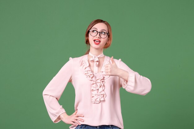 Vorderansicht Lehrerin in rosa Bluse auf Grün