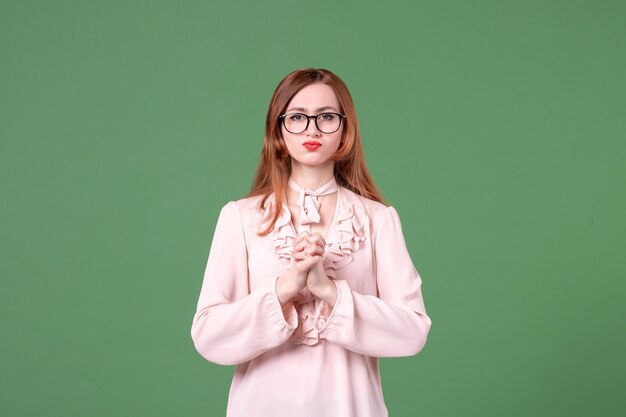 Vorderansicht Lehrerin in rosa Bluse auf grünem Hintergrund Arbeitsbuch Student Job Frau junge Lektion College Farbe Schule
