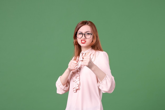 Vorderansicht Lehrerin in rosa Bluse auf grünem Hintergrund Farbe Arbeitsbuch Student junge Lektion College Schule Job Frau Bibliothek