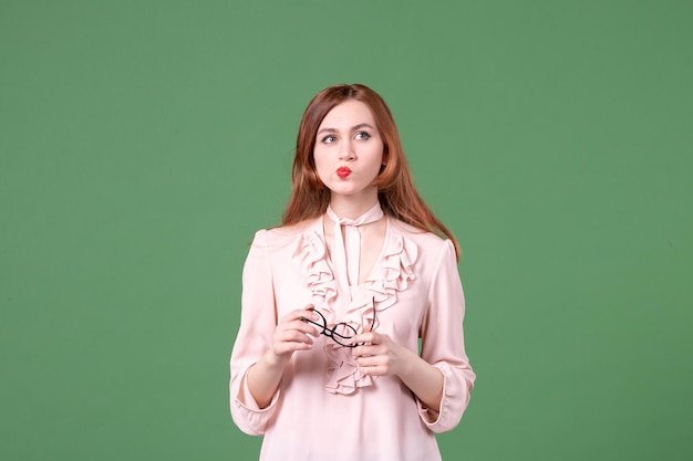 Vorderansicht lehrerin in rosa bluse auf grünem hintergrund schulbibliothek college lektion arbeitsbuch student junge frau farbe