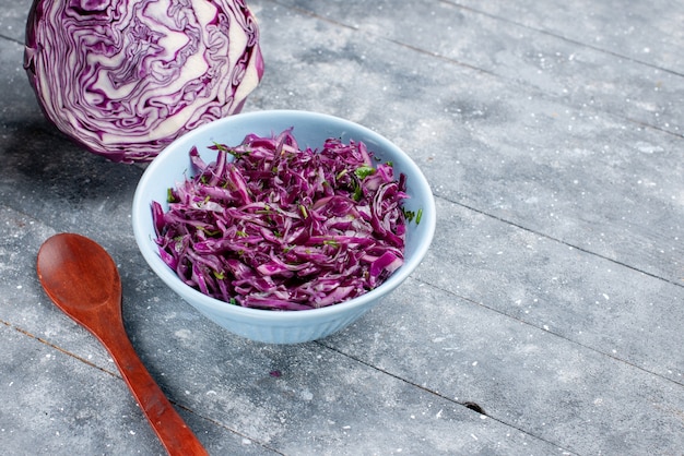 Vorderansicht lila Kohl reif frisch geschnitten und ganz auf der grauen rustikalen Oberfläche Gemüse reifen Lebensmittel Vitaminfarbe