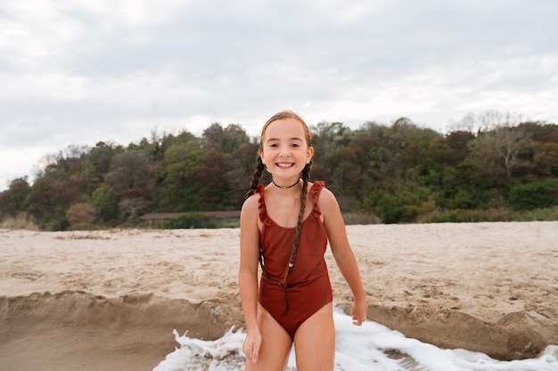 Kostenloses Foto vorderansicht-mädchen, das spaß am strand hat