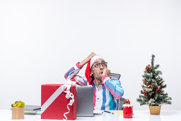 Vorderansicht männlicher Arbeiter sitzt an seinem Arbeitsplatz Büro Emotion Job Weihnachtsgeschäft Arbeit