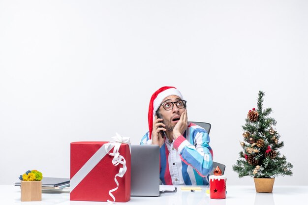 Vorderansicht männlicher Arbeiter sitzt an seinem Platz mit Laptop reden