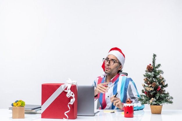 Vorderansicht männlicher Arbeiter sitzt an seinem Platz mit Laptop und Dateien arbeiten