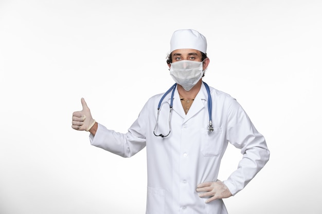 Vorderansicht männlicher Arzt im medizinischen Anzug mit Maske als Schutz vor einer kovidpandemischen Erkrankung an der White-Wall-Virus-Krankheit