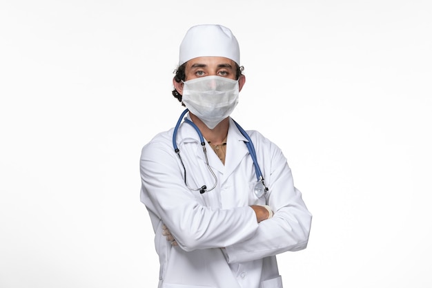 Vorderansicht männlicher Arzt im medizinischen Anzug und Tragen einer Maske als Schutz vor einer Gesundheits-Kovid-Pandemie