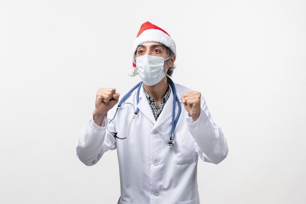 Vorderansicht männlicher Arzt mit Maske auf weißem Boden Pandemie Covid Holiday Virus