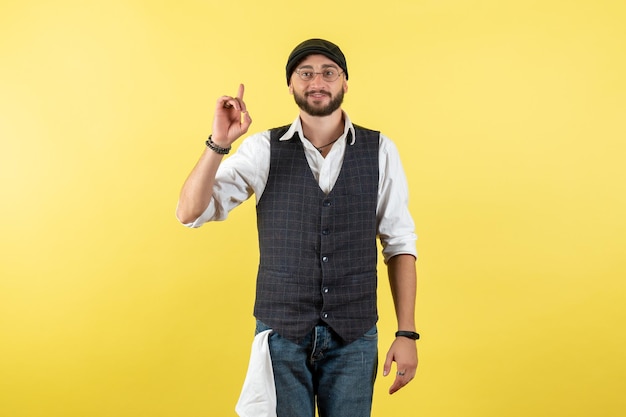 Vorderansicht männlicher Barkeeper, der seinen Finger auf die gelbe Wand hebt, Modell trinken Arbeit Job Club männliche Nacht