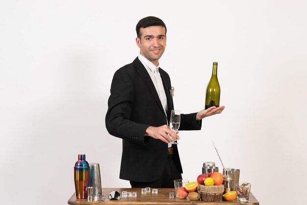 Vorderansicht männlicher Barkeeper im klassischen Anzug, der Getränke auf der weißen Wand macht Nachtclub männliche Bar trinkt Alkohol