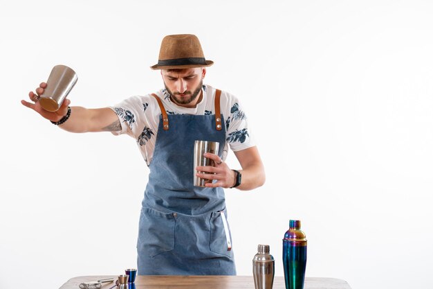 Vorderansicht männlicher Barkeeper vor der Bar, der ein Getränk auf der weißen Wandbar zubereitet Alkohol Nachtjob Obstgetränk Club